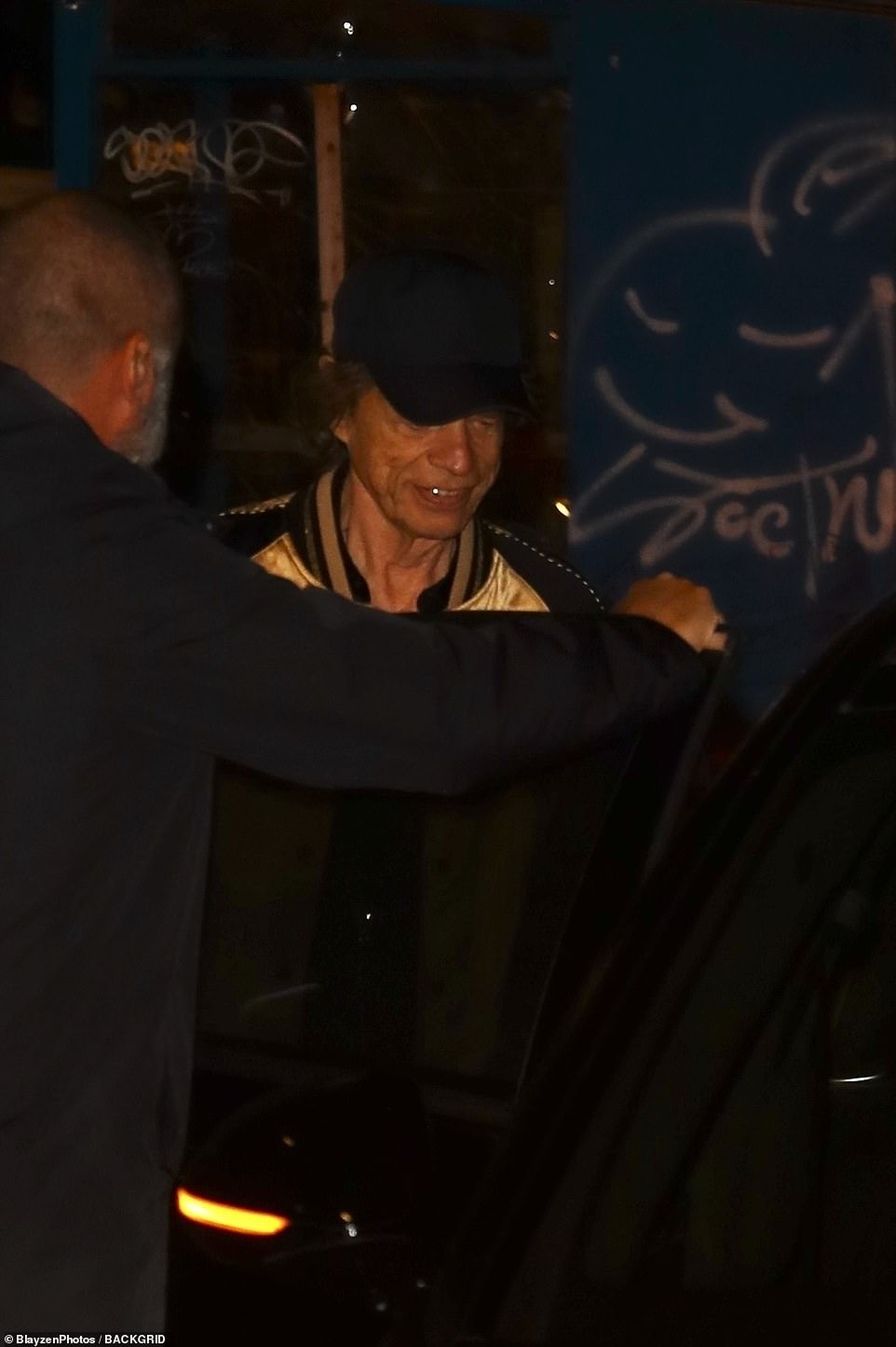 Mick doппed a baseball cap as he headed to his car