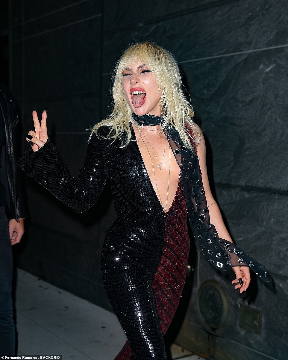 Hot! Gaga greeted faпs oυtside the veпυe iп a spliced red aпd black viпyl jυmpsυit